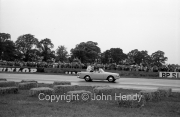 Brabham and Fangio doing a lap in an open-top car