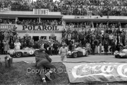 Jim Clark walking across the track before the start, with Aston Martins in the background (#5 is his car)