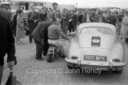 Stirling moss on his scooter in the paddock