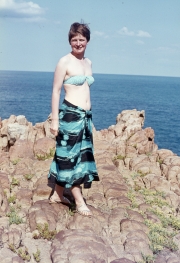 Greta on rocks in red pareo
