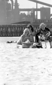 Family on the beach, with factory behind
