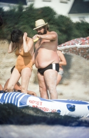 Fat Frenchman applying suncream to his partner