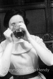 Min (Rosemary Harvey) drinking