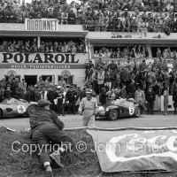 Jim Clark walking across the track before the start, with Aston Martins in the background (#5 is his car)