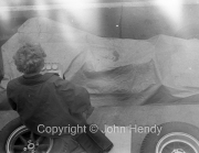 Formula 1 - Covered car in the pits, with lady timekeeper