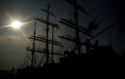 Russian tall ship manning the yards, against the sun