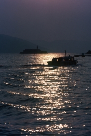 Sun track across the water, with boat and Monastery
